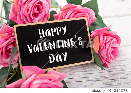 Small chalkboard for Valentine's day. Background with pink roses. 44014278