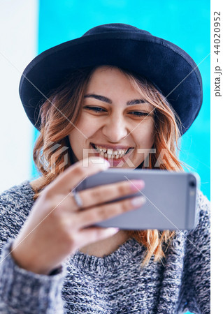 a young beautiful girl communicating through a smartphone a young beautiful girl communicating through a smartphone 44020952