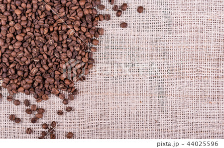 Roasted coffee beans on sack fabric background 44025596