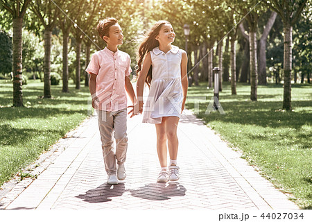 Friendship. Little boy and girl walking on the road in the park  44027034