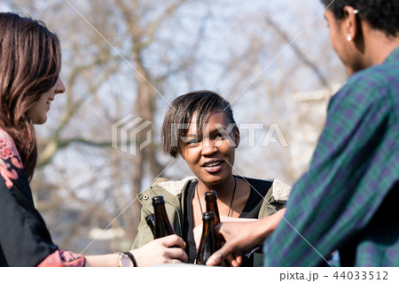 Diverse friends enjoying the drinks in park Diverse friends enjoying the drinks in park 44033512