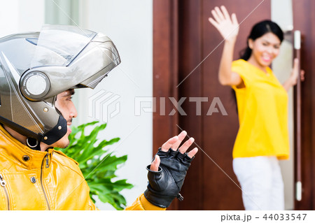 Woman saying goodbye to her boyfrined wearing helmet 44033547