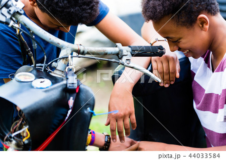 Close-up of male friends looking at motorbike 44033584