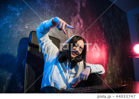 Excited female gamer girl woman pressing a button on a keyboard running a game or sending a message 44033747