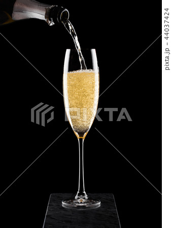 Pouring yellow champagne from bottle to glass  44037424