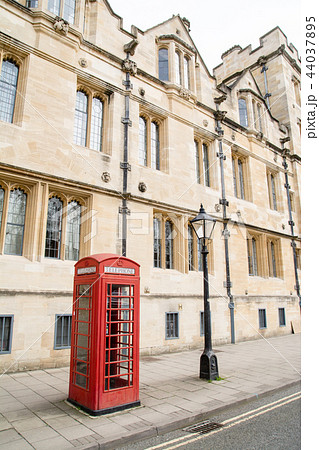 イギリスオックスフォードの石造りの歴史的な建物と赤い電話ボックスの写真素材