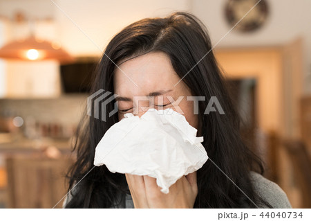 Young woman having flu, blowing her nose. 44040734