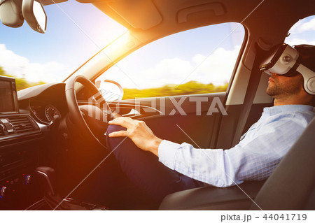 man behind the wheel wearing a virtual reality helmet man behind the wheel wearing a virtual reality helmet 44041719