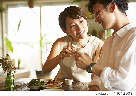 部屋でお酒を飲む男女 部屋でお酒を飲む男女 44042902