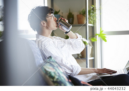 部屋でお酒を飲む男性 44043232