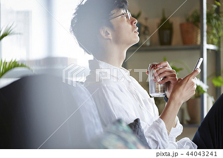 部屋でお酒を飲む男性 44043241