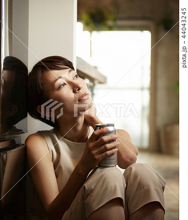 部屋でお酒を飲む女性の写真素材