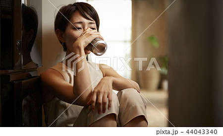 部屋でお酒を飲む女性 44043340