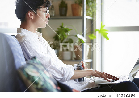 部屋でお酒を飲む男性 44043394