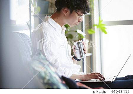 部屋でお酒を飲む男性 44043415