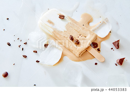 Summer healthy vegan frozen melting coffee latte popsicles with coffee beans over marble background 44053383
