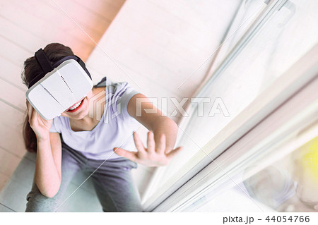 Positive delighted brunette schoolgirl wearing VR glasses 44054766