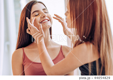 Positive delighted teenagers doing local face mask 44054829