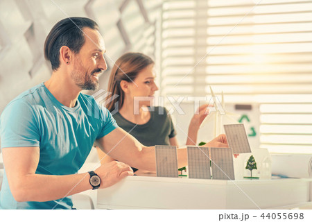 Pleased bearded man playing with details of project 44055698