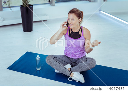 Happy mature woman speaking on phone during training 44057485