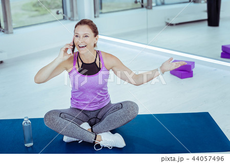 Enthusiastic mature woman talking on phone during training 44057496