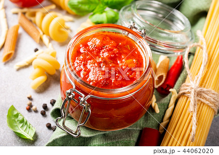Glass jar with homemade classic spicy tomato pasta or pizza sauce. 44062020