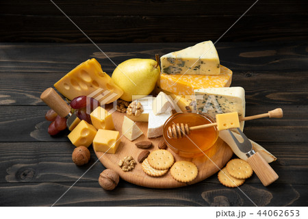 Various types of cheese on a rustic wooden table 44062653