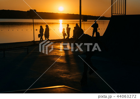 people are resting on a sports field by the river bank 44063272