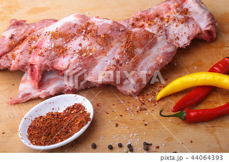 Raw steak on rustic cutting board with salt pepper Raw steak on rustic cutting board with salt pepper 44064393