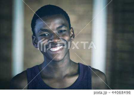 Smiling high school boy standing in the sports court Smiling high school boy standing in the sports court 44068496
