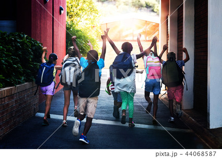 Rear view of classmates running at school campus 44068587