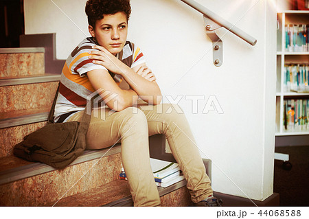 Sad schoolboy sitting alone on staircase Sad schoolboy sitting alone on staircase 44068588