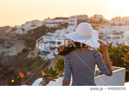 Santorini travel tourist brunette woman visiting famous white Oia village. 44069036