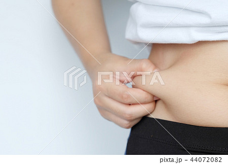 Side of woman hand catching fat body belly paunch Side of woman hand catching fat body belly paunch 44072082