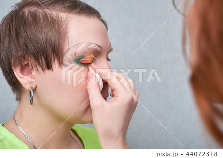 Professional visage artist applying artistic make-up on woman's face in salon. Professional visage artist applying artistic make-up on woman's face in salon. 44072318