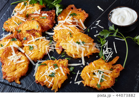 Tasty crispy fritters from pumpkin with saur cream 44073882