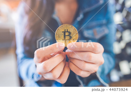 The hand of a woman holding a currency, bitcoin. The hand of a woman holding a currency, bitcoin. 44073924