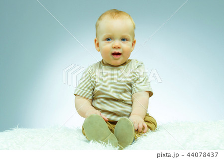 Cute beautiful newborn on a blue background looking at camera and smiling 44078437
