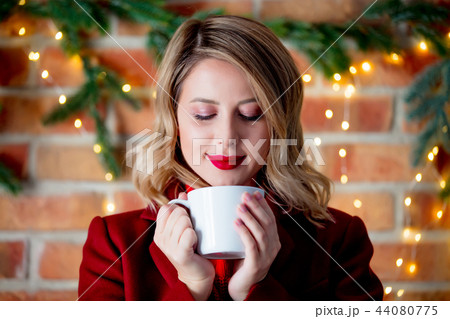young girl in red coat with cup of coffee young girl in red coat with cup of coffee 44080775