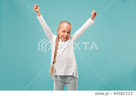 Happy success teen girl celebrating being a winner. Dynamic energetic image of female model Happy success teen girl celebrating being a winner. Dynamic energetic image of female model 44082323