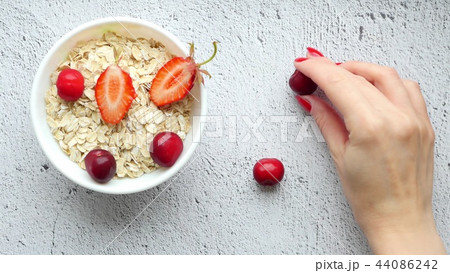 Beautiful female hands lay out on the table a composition of bright berries - 6. Juicy red cherries Beautiful female hands lay out on the table a composition of bright berries - 6. Juicy red cherries 44086242