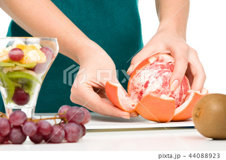 Cook is peeling grapefruit for fruit dessert 44088923