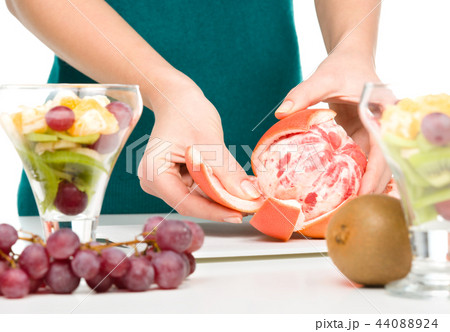 Cook is peeling grapefruit for fruit dessert Cook is peeling grapefruit for fruit dessert 44088924
