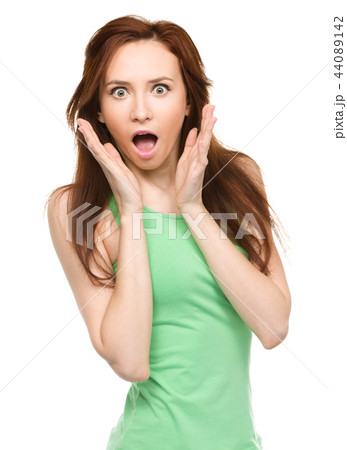 Woman is holding her face in astonishment Woman is holding her face in astonishment 44089142