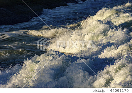 Wave foam advancing on the rocks of Ipanema beach 44091170
