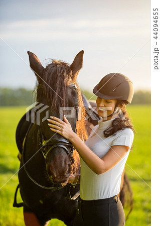 Young Woman with her horse at sunrise. Young Woman with her horse at sunrise. 44094655