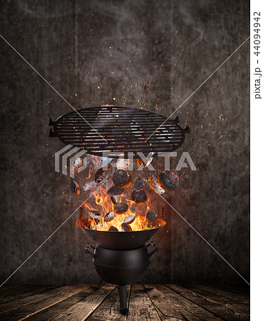 Kettle grill with hot briquettes and cost iron grid flying in the air. Kettle grill with hot briquettes and cost iron grid flying in the air. 44094942