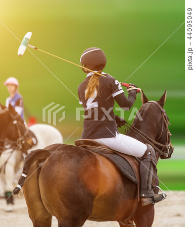 Polo woman player is riding on a horse. Polo woman player is riding on a horse. 44095049