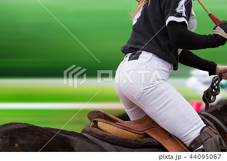 Polo woman player is riding on a horse. 44095067
