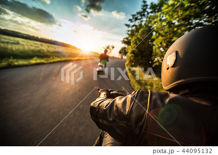 Motorcycle driver riding in Alpine highway, handlebars view, Austria, Europe. Motorcycle driver riding in Alpine highway, handlebars view, Austria, Europe. 44095132